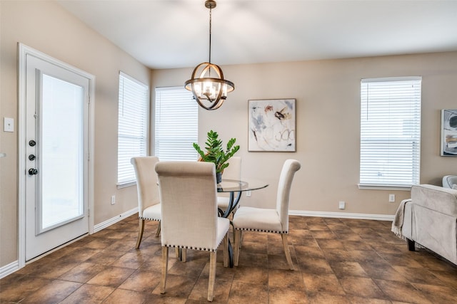 dining area featuring baseboards, an inviting chandelier, and a healthy amount of sunlight