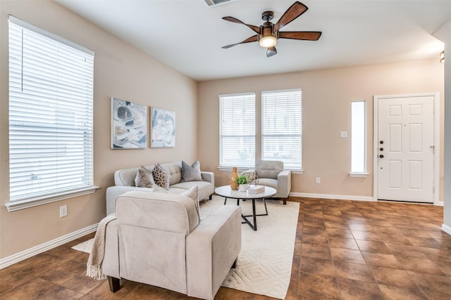 living room with visible vents, baseboards, and a ceiling fan