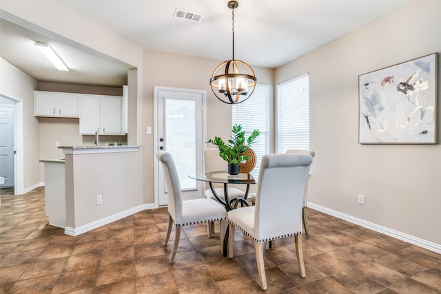 dining room with baseboards, visible vents, and a notable chandelier