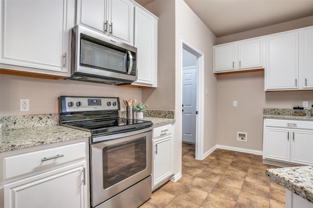 kitchen featuring baseboards, stainless steel appliances, light stone counters, and white cabinets