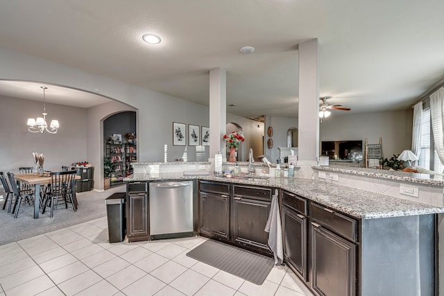 kitchen with ceiling fan with notable chandelier, a sink, dark brown cabinets, light stone countertops, and dishwasher