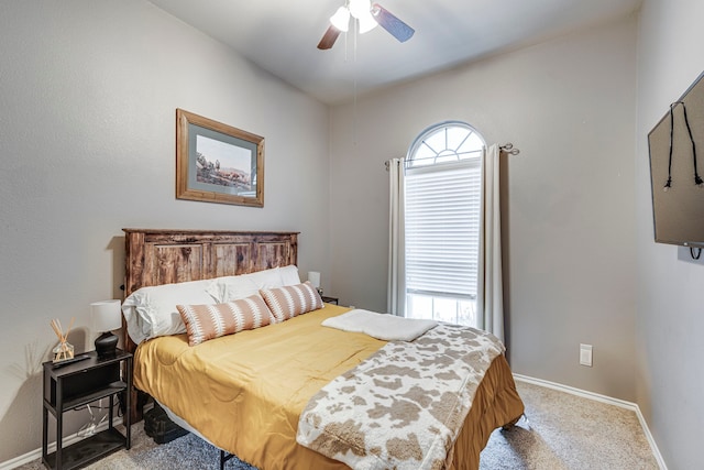 carpeted bedroom featuring multiple windows, baseboards, and a ceiling fan