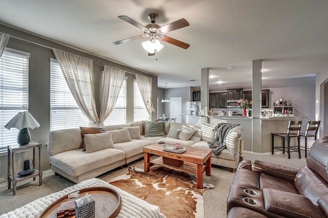 living area featuring a ceiling fan and light colored carpet