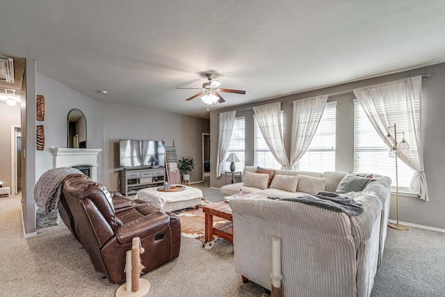 living room with plenty of natural light, a fireplace, light carpet, and baseboards