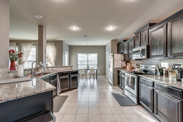 kitchen with light stone counters, light tile patterned flooring, a sink, visible vents, and appliances with stainless steel finishes