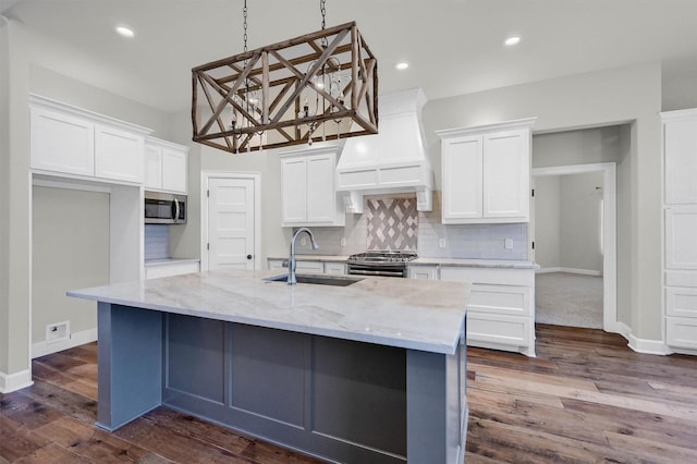 kitchen featuring stainless steel appliances, custom range hood, backsplash, white cabinets, and a sink