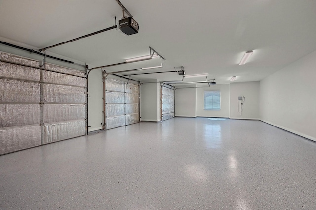 garage with a garage door opener and baseboards