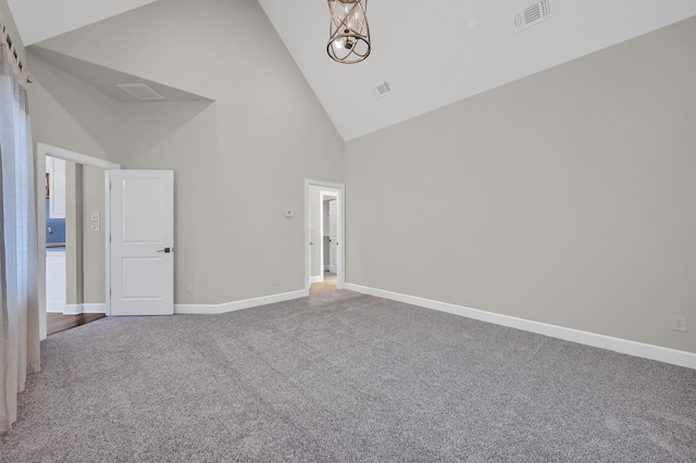 carpeted empty room featuring high vaulted ceiling, an inviting chandelier, visible vents, and baseboards