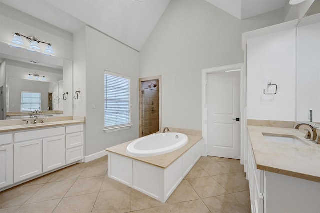 bathroom with a tile shower, two vanities, a sink, and tile patterned floors