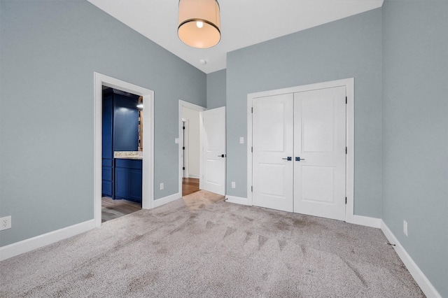 unfurnished bedroom with carpet, a closet, and baseboards