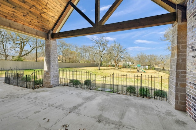 view of patio featuring a playground and fence