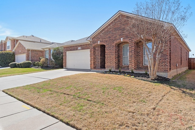 single story home featuring a garage, concrete driveway, brick siding, and a front yard