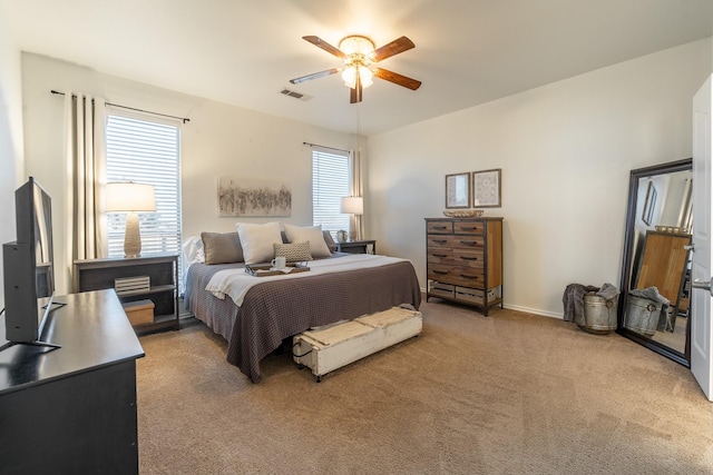 bedroom featuring light carpet, ceiling fan, and visible vents