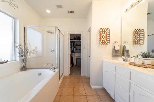 full bath featuring a stall shower, tile patterned flooring, visible vents, and a walk in closet