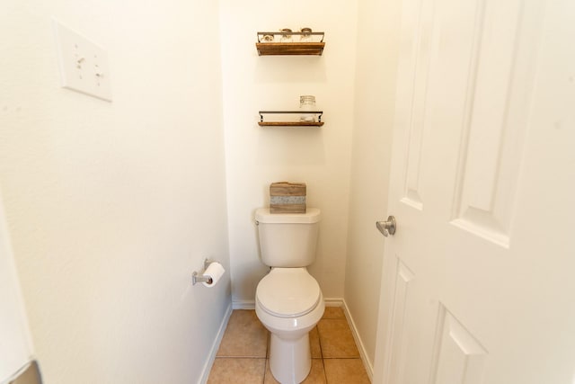 bathroom featuring baseboards, toilet, and tile patterned floors