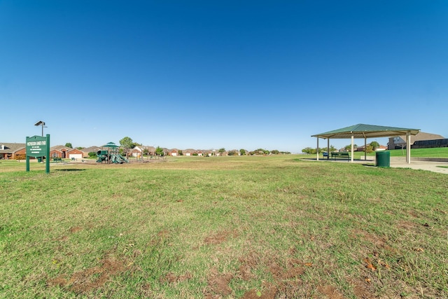 view of yard with playground community and a detached carport