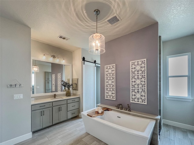 bathroom with visible vents, vanity, and wood tiled floor