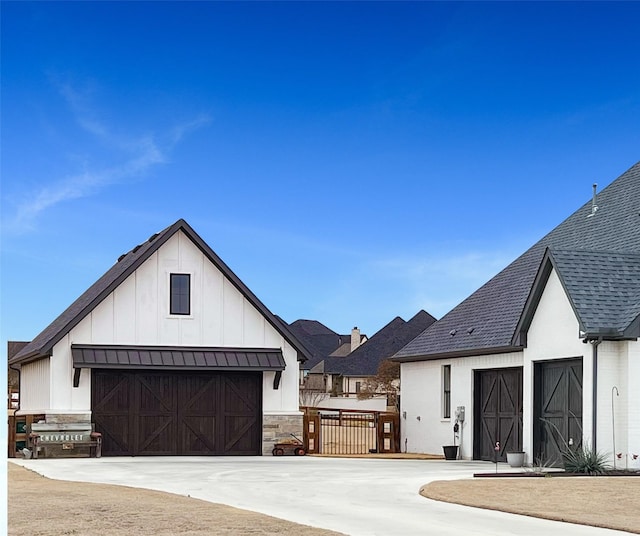 exterior space with an outbuilding, a standing seam roof, board and batten siding, a shingled roof, and metal roof