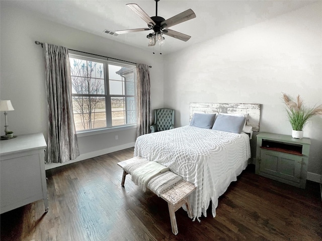 bedroom with visible vents, baseboards, wood finished floors, and a ceiling fan