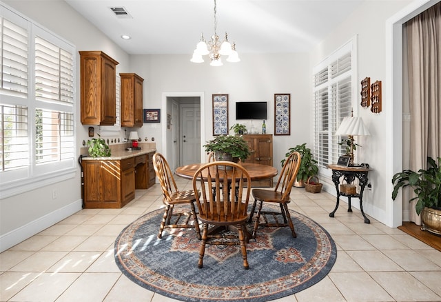 dining room featuring baseboards, light tile patterned flooring, visible vents, and a notable chandelier