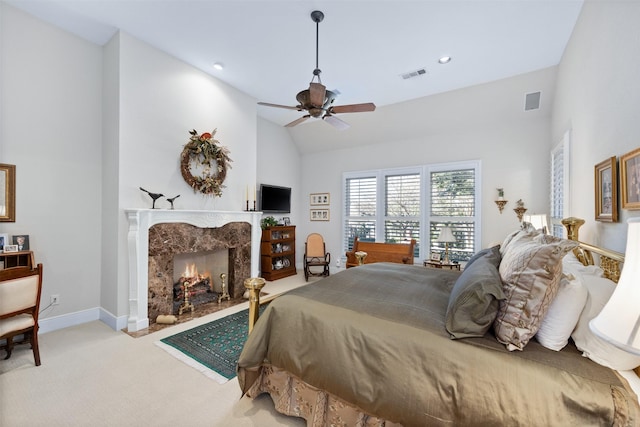 carpeted bedroom featuring vaulted ceiling, visible vents, a fireplace, and baseboards