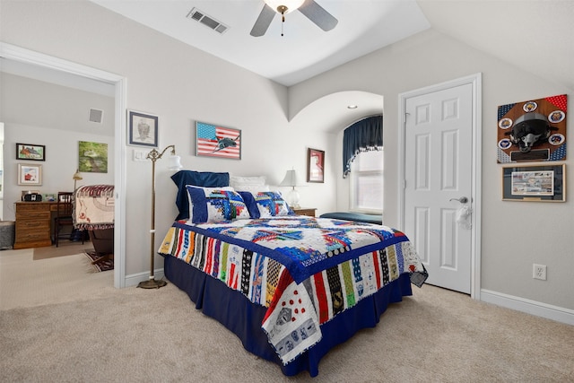 carpeted bedroom with baseboards, visible vents, vaulted ceiling, and a ceiling fan