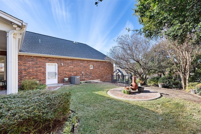 view of yard featuring central AC and fence