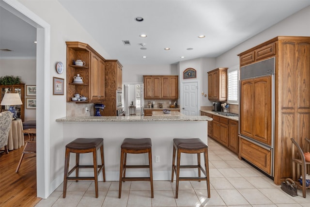 kitchen featuring open shelves, visible vents, decorative backsplash, appliances with stainless steel finishes, and a peninsula