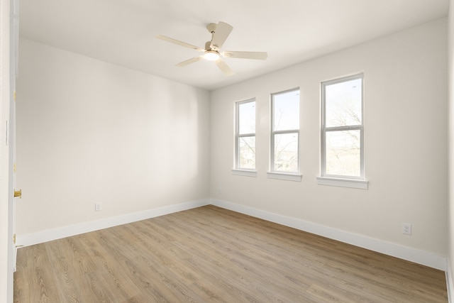 empty room featuring light wood-type flooring, ceiling fan, and baseboards