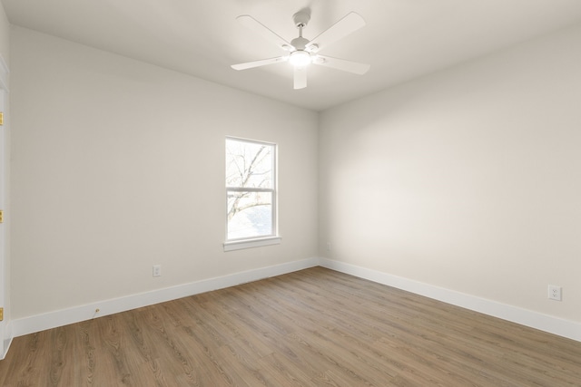 spare room featuring ceiling fan, wood finished floors, and baseboards