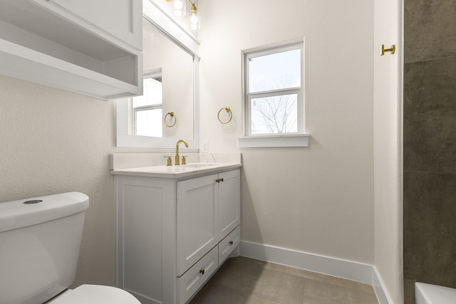 bathroom featuring toilet, tile patterned floors, baseboards, and vanity