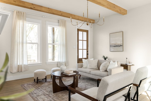 living room with a chandelier, beamed ceiling, baseboards, and wood finished floors