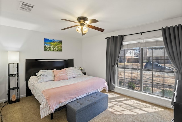 carpeted bedroom with ceiling fan, visible vents, and baseboards