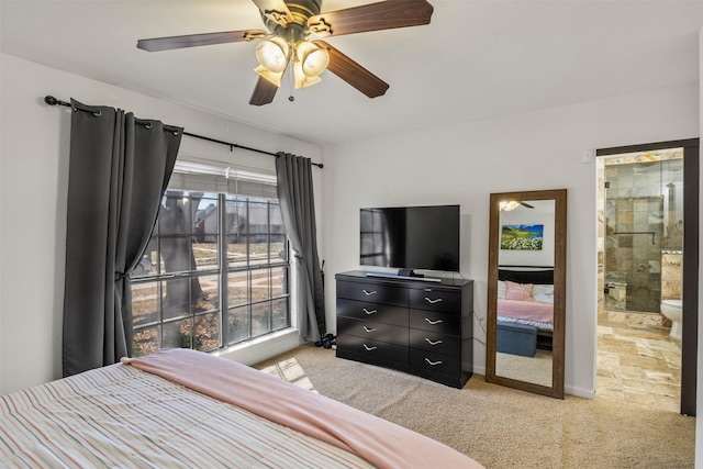 bedroom featuring a ceiling fan, light carpet, and connected bathroom