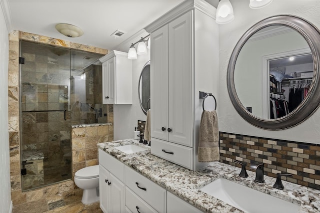 full bath with toilet, a stall shower, backsplash, and a sink