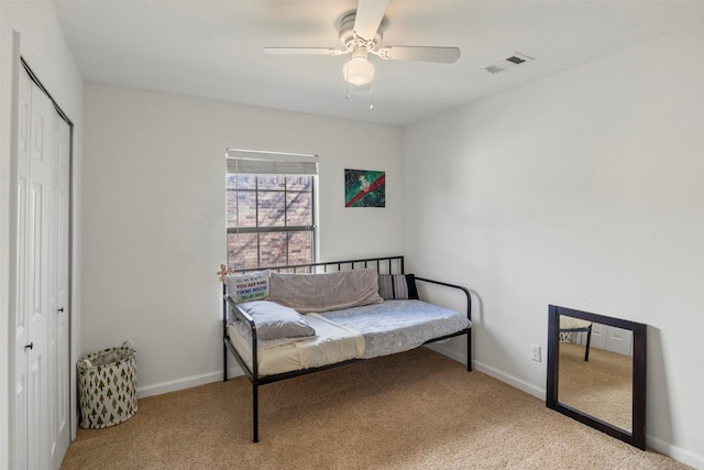 carpeted bedroom featuring ceiling fan, a closet, visible vents, and baseboards