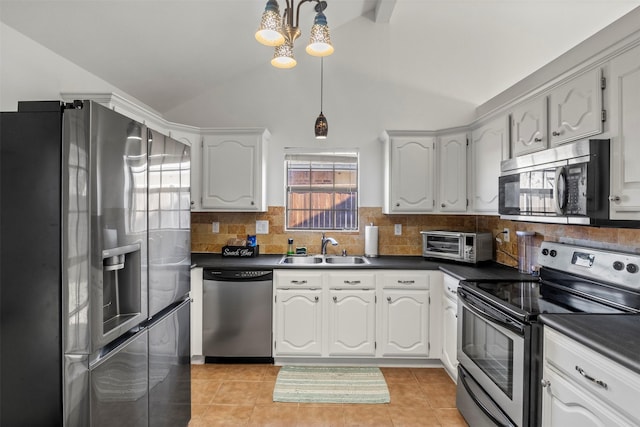 kitchen featuring light tile patterned floors, a toaster, stainless steel appliances, a sink, and dark countertops