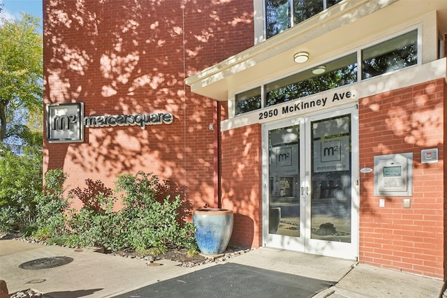 property entrance featuring brick siding and french doors