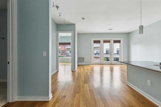 interior space with baseboards, visible vents, and light wood finished floors