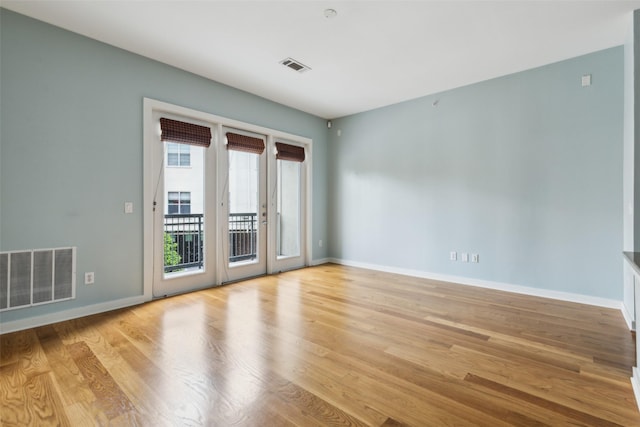 spare room featuring visible vents, light wood-style flooring, french doors, and baseboards