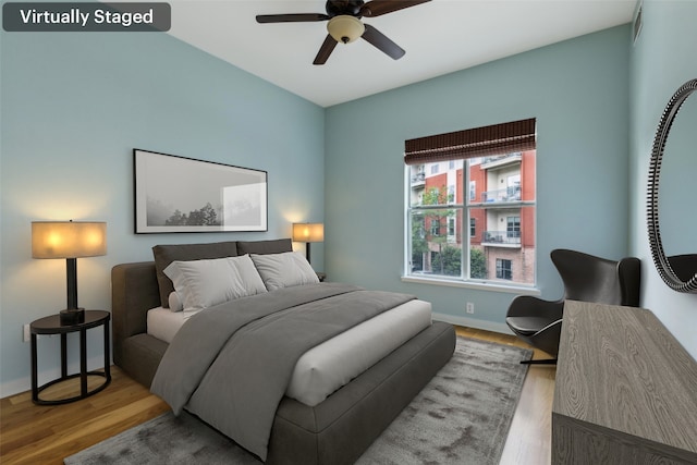 bedroom featuring wood finished floors, ceiling fan, and baseboards
