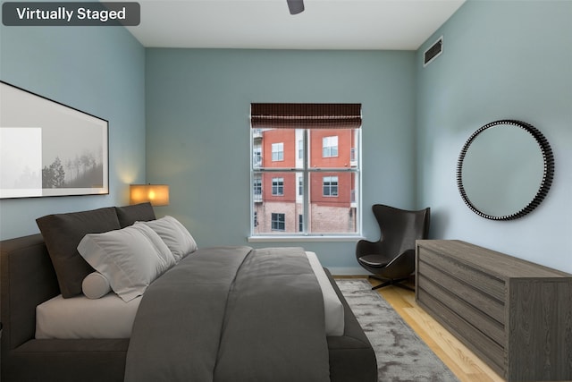 bedroom with visible vents, light wood finished floors, and baseboards
