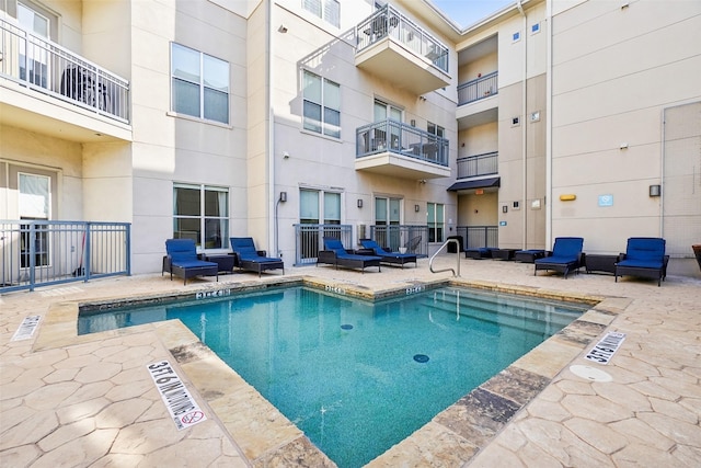 pool with a patio and an outdoor hangout area