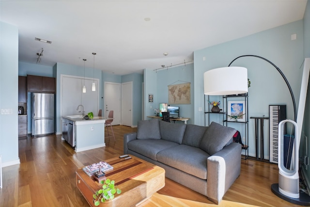 living area featuring visible vents, baseboards, and wood finished floors