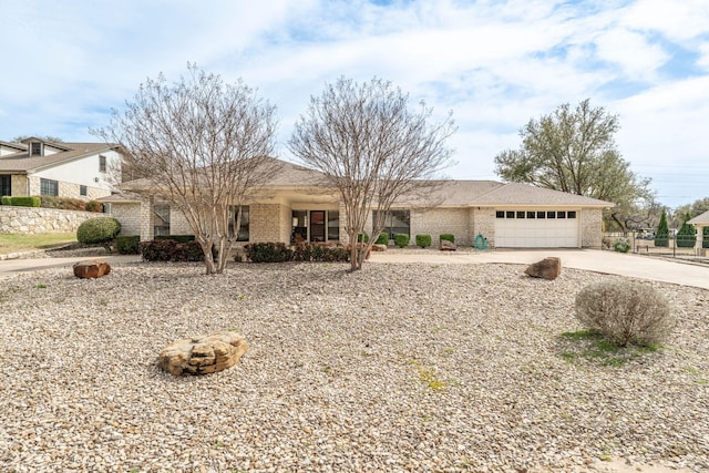 ranch-style house featuring concrete driveway, brick siding, an attached garage, and fence