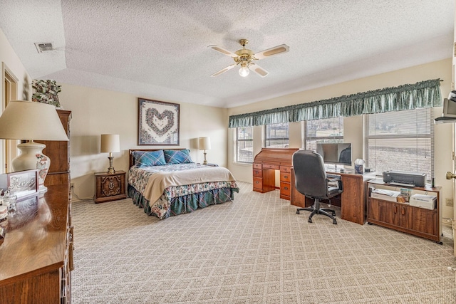 bedroom with light carpet, a textured ceiling, visible vents, and a ceiling fan