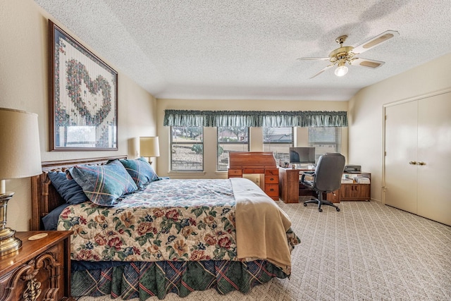 carpeted bedroom with a closet, visible vents, ceiling fan, and a textured ceiling