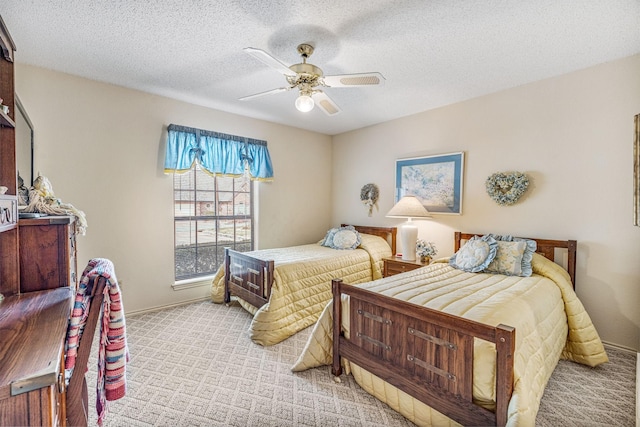 bedroom featuring a ceiling fan, light carpet, a textured ceiling, and baseboards