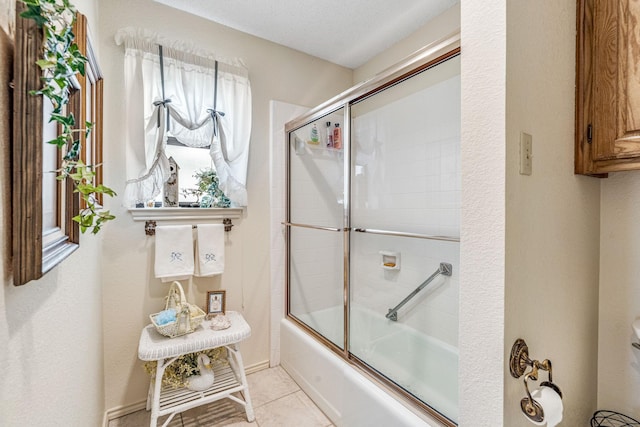 bathroom with tile patterned flooring and combined bath / shower with glass door