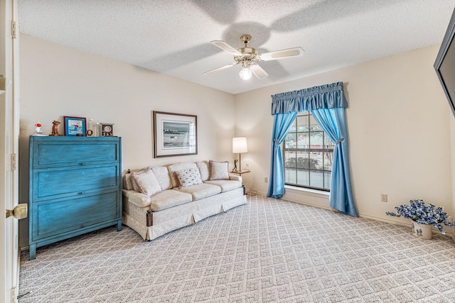 living room featuring a textured ceiling, carpet floors, a ceiling fan, and baseboards